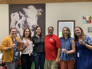 Group of people with cow image in background