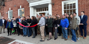 Group of people outside building cutting a ribbon