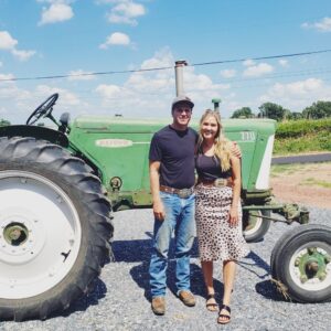 couple in front of green tractor