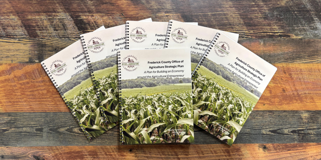Wood background with copies of Frederick County Agriculture Strategic Plan