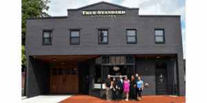 True Standard Distilling Facility- Gray building with windows and staff standing in front