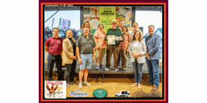 man receiving an award on a stage with many supporters