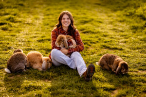Mia McGuffin in a field with three rabbits