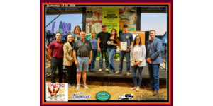 Group of people receiving an award. Standing on a stage in a fair show ring.
