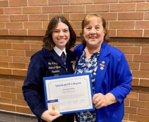 two people smiling with an award 
